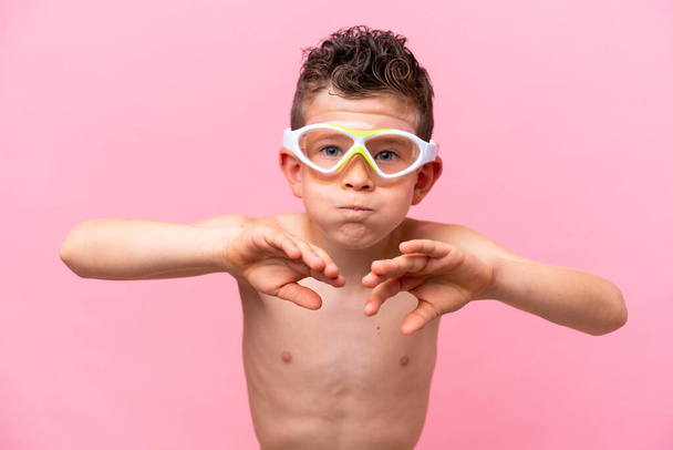 Little caucasian boy wearing a diving goggles isolated on pink background - Photo, Image