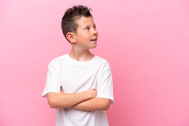 Little caucasian boy isolated on pink background with arms crossed and happy - Photo, image