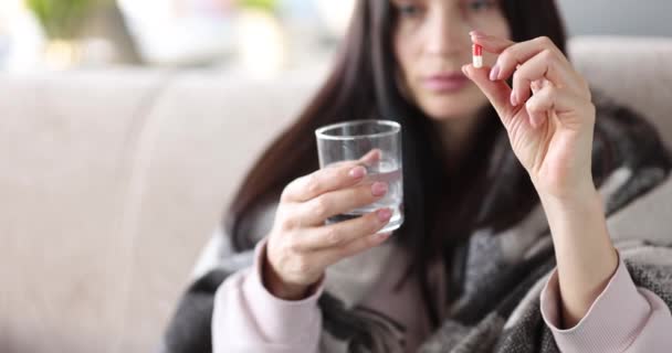 Kobieta trzyma tabletki medyczne i szklankę wody - Materiał filmowy, wideo
