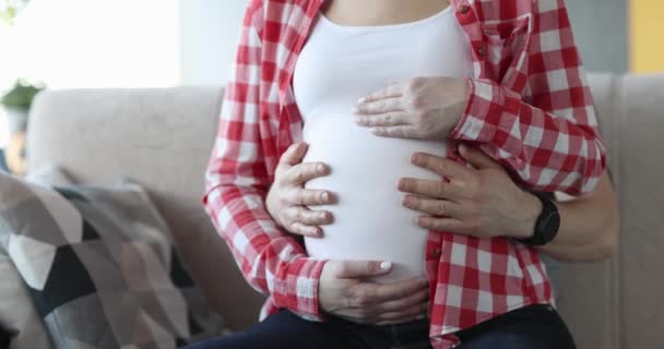 Hombre y mujer están acariciando el vientre en el último mes de embarazo - Metraje, vídeo