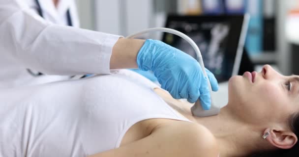 Médico en el centro de diagnóstico hace ultrasonido de la glándula tiroides - Imágenes, Vídeo