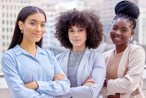 Women taking over the business world. Shot of a group of young businesswomen standing with their arms crossed against a city background. - Photo, Image