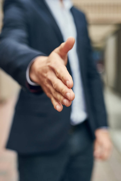 Its my pleasure to welcome you. Closeup shot of an unidentifiable businessman gesturing for a handshake. - Photo, Image