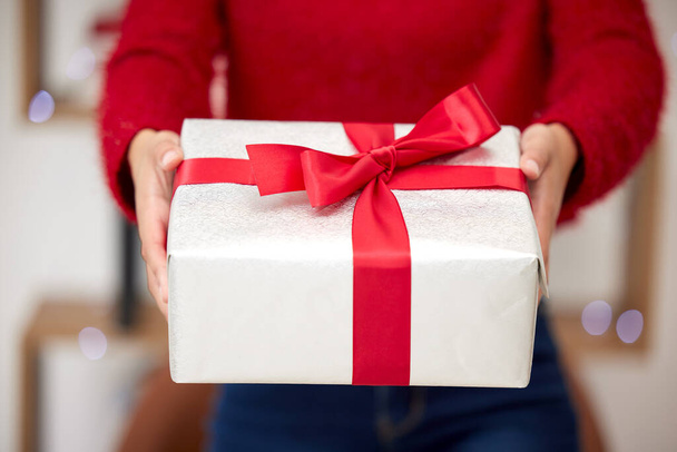 No olvidamos el verdadero significado de la Navidad. Fotografía de una mujer irreconocible abriendo regalos durante la Navidad en casa. - Foto, imagen