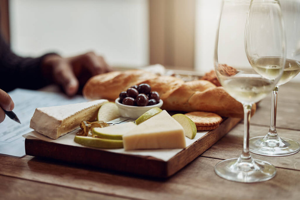 Şarabına iyi gelecek bir şey. Peynir tabağının tadını çıkaran ve farklı şarapların tadına bakan bir adamın fotoğrafı.. - Fotoğraf, Görsel