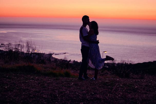 Безумно влюблён. Полнометражный снимок любящей молодой пары, силуэт на закате. - Фото, изображение