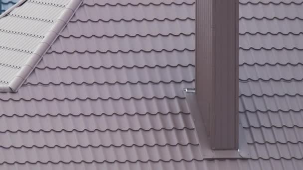 Καμινάδα στο σπίτι στέγη κορυφή καλύπτονται με μεταλλικό έρπητα ζωστήρα υπό κατασκευή. Κάλυψη κτιρίου με πλακάκια. Ανάπτυξη ακινήτων - Πλάνα, βίντεο