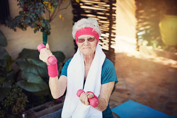 Le levage n'a aucune limite d'âge. Prise de vue d'une femme âgée faisant de l'exercice à la maison. - Photo, image