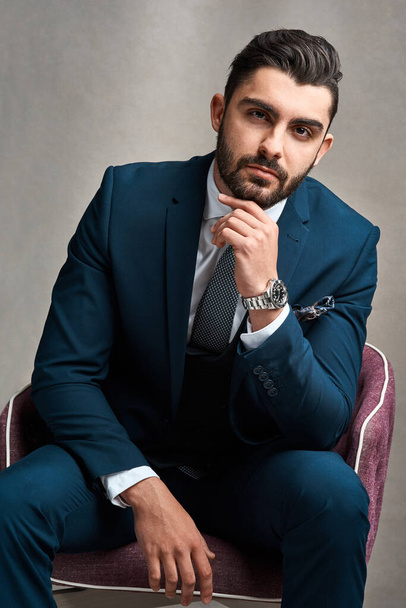 You can work for a boss or be the boss. Studio portrait of a stylishly dressed young businessman sitting on a chair against a grey background. - Photo, Image