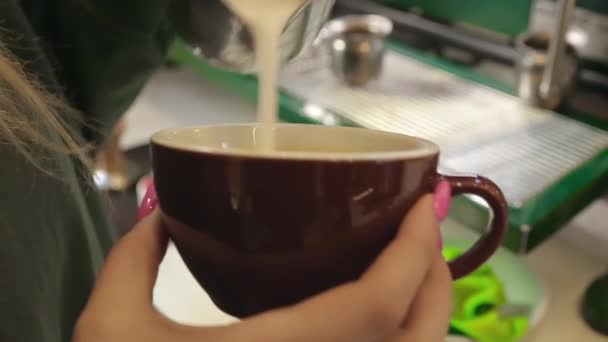 Baristatyttö piirtää cappuccinoon. Cappuccinon valmistaminen kahvilassa - Materiaali, video