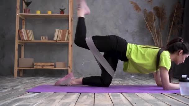Woman during her fitness workout at home with rubber resistance band, home sport - Video, Çekim