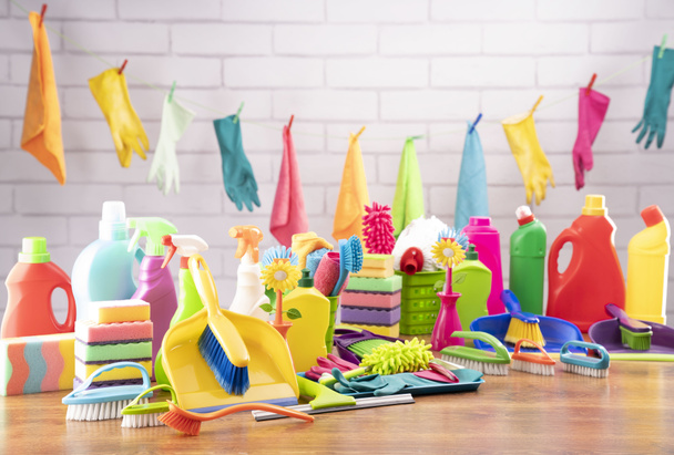 Spring house cleaning. Colorful cleaning kit on white wall background. - Foto, immagini