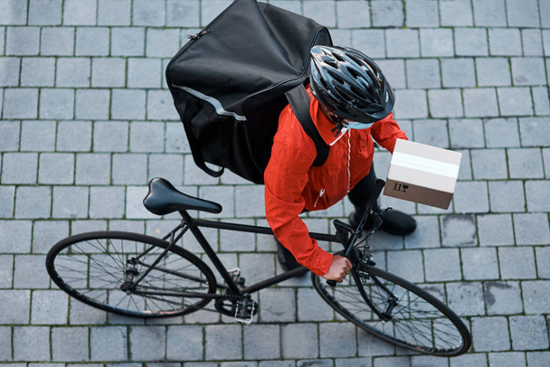 Trust us to deliver your goods on time and in one piece. Shot of a masked man out with his bicycle to do a delivery. - Fotografie, Obrázek