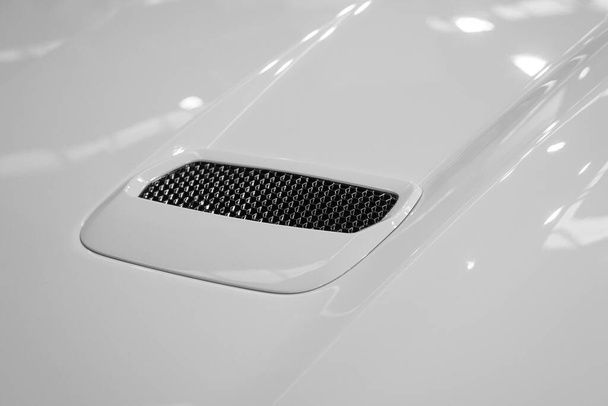 Detail of the exhaust on the hood of a tuned car with white paint - Valokuva, kuva
