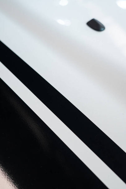 Detalle de rayas negras una superficie metálica blanca en la capucha de un coche afinado - Foto, Imagen