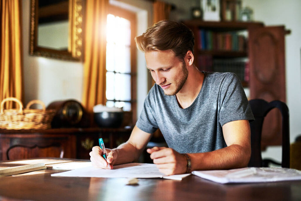 This assignment is not challenging at all. Cropped shot of a young man working on a project at home. - Fotoğraf, Görsel