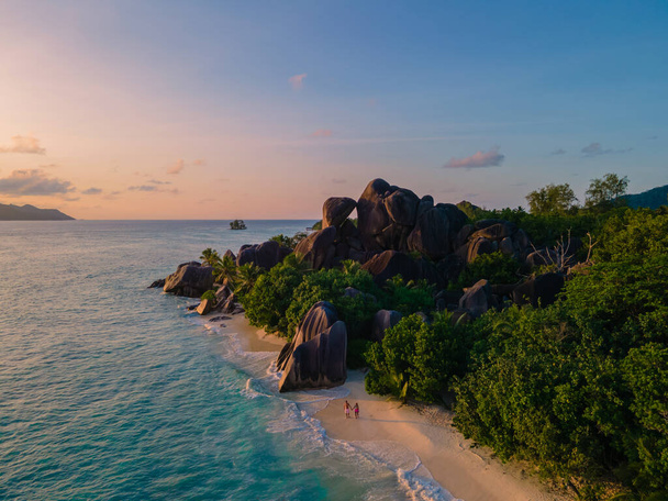 Anse Source dArgent Strand, Insel La Digue, Seyshellen, Drone Luftaufnahme von La Digue Seychellen Vogelperspektive, Paar Männer und Frauen am Strand beim Sonnenuntergang in einem Luxus-Urlaub - Foto, Bild