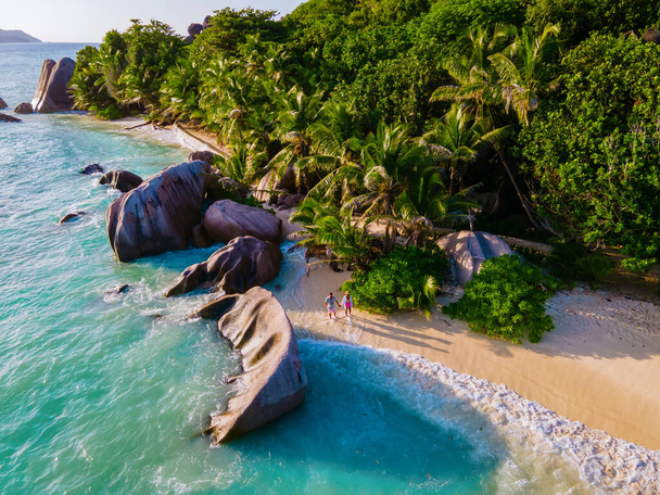 Anse Source dArgent beach, La Digue Island, Seyshelles, Drone aerial view of La Digue Seychelles bird eye view, couple men and woman walking at the beach during sunset at a luxury vacation - Fotografie, Obrázek