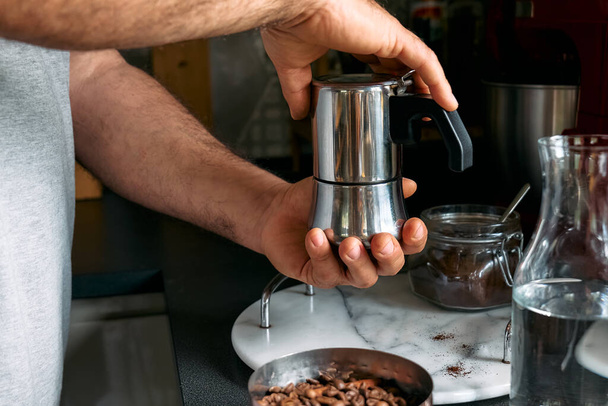 Man preparing classic Italian coffee in the mocha in the kitchen. Coffee brake. Morning habit. - Φωτογραφία, εικόνα