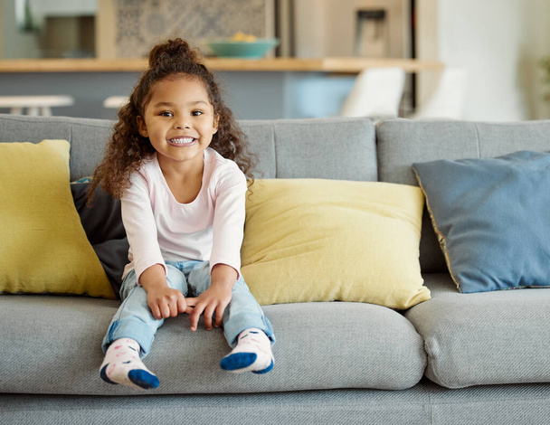 Sie liebt die Wochenenden auf der Couch. Porträt eines kleinen Mädchens, das zu Hause auf dem Sofa sitzt. - Foto, Bild