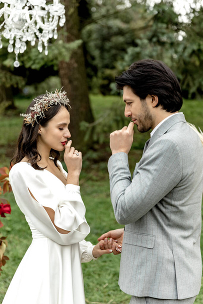 Az esküvői szertartás a gyűrűk felhúzásának hagyományos pillanata. A menyasszony és a vőlegény esküt tesznek egymásnak. Kiváló minőségű fénykép - Fotó, kép