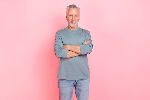 Photo of pretty attractive retired man wear grey shirt arms folded smiling isolated pink color background - Fotografie, Obrázek