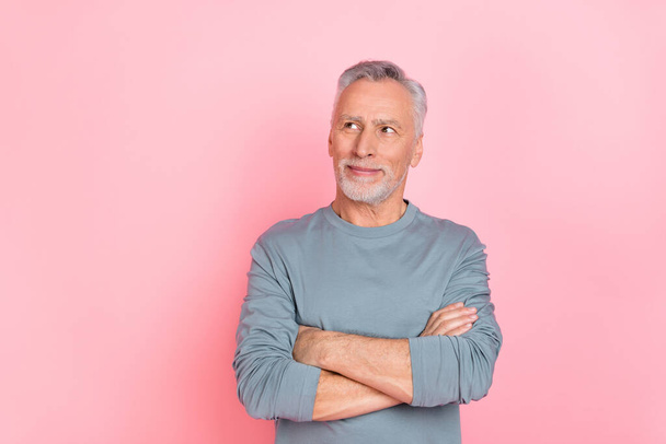 Photo of attractive dreamy retired man wear grey shirt arms folded looking empty space isolated pink color background - Photo, Image