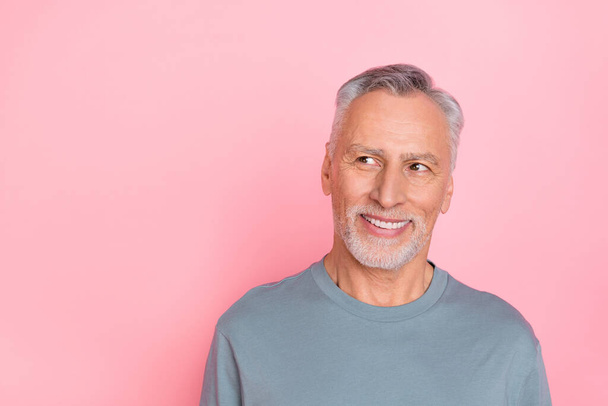 Photo of confident dreamy man pensioner dressed grey shirt looking empty space isolated pink color background - Fotoğraf, Görsel