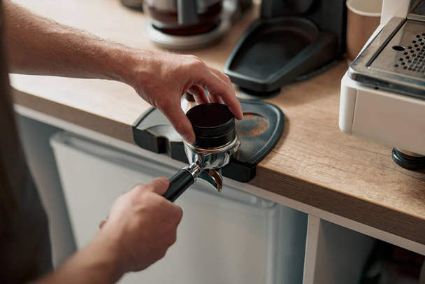 Barista presionando café molido en portafilter con manipulación - Foto, Imagen