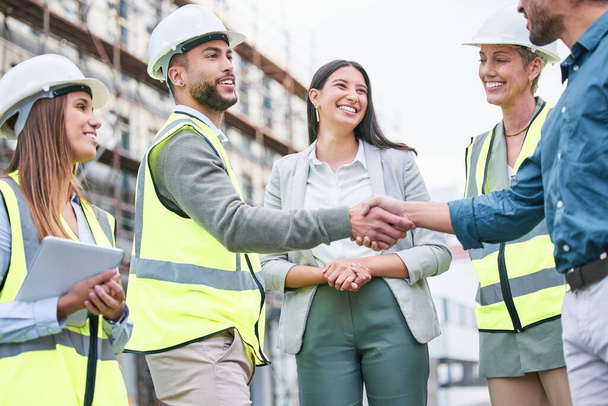 When we strive to become better than we are. Shot of a team of builders shaking hands on a construction site outside. - Foto, immagini