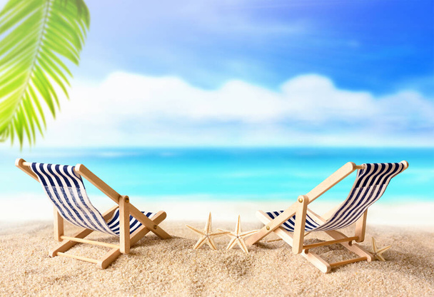 Nyaralás nyaralás háttér koncepció - két strand lounge szék tenyér alatt a nyári strandon - Fotó, kép