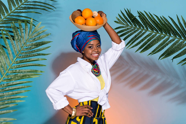 Quênia senhora segurar cabeça eco mandarin coco maduro verão vegetariano desgaste nativo vestido accessorries isolado teal cor fundo - Foto, Imagem