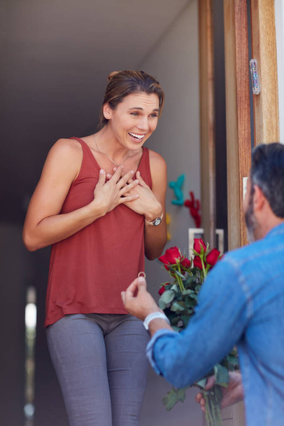 Of course Ill marry you. Cropped shot of an attractive young woman accepting a marriage proposal while standing on her doorway at home. - Foto, imagen