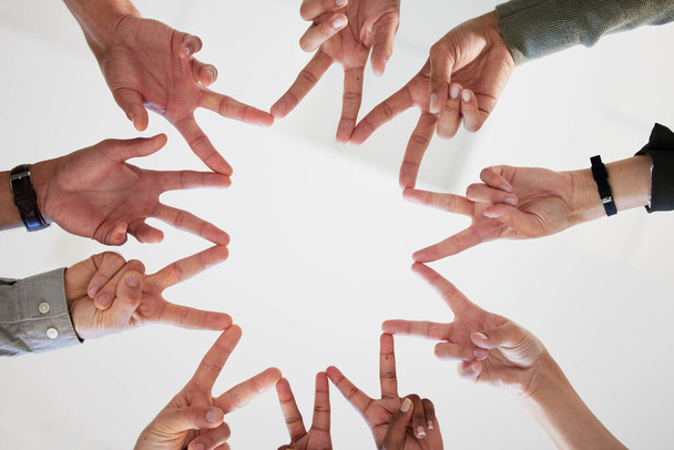 Dont let the mindless clutter your path. Below shot of a group of unrecognizable businesspeople joining their hands against a white background. - 写真・画像