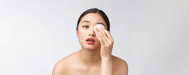 huidverzorging vrouw verwijderen van gezicht make-up met wattenstaafje - huidverzorging concept. Gezichtsclose-up van mooie gemengde ras model met een perfecte huid. - Foto, afbeelding
