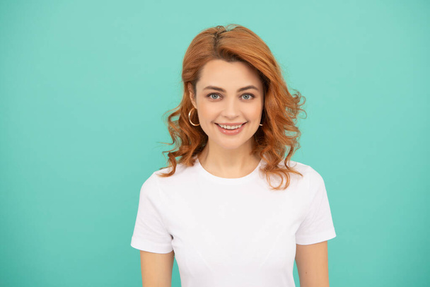 happy redhead girl with curly hair on blue background - Fotografie, Obrázek