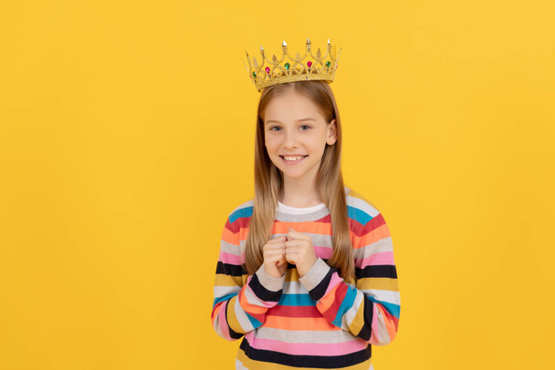 cheerful teen child in queen crown on yellow background - Photo, Image