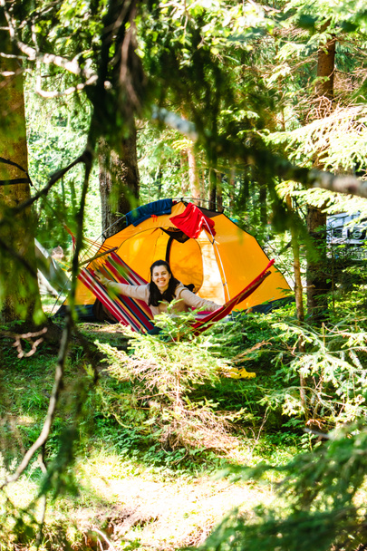 женщина лежит в гамаке в лесной палатке на заднем плане копировать пространство летом - Фото, изображение