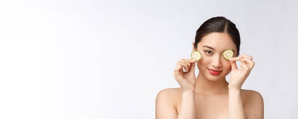 Natural casero fresco pepino facial almohadillas para los ojos máscaras faciales. Mujer asiática sosteniendo almohadillas de pepino y sonrisa relajarse con natural casero
 - Foto, Imagen