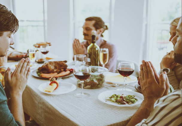 Vrolijke multi-etnische vrienden hebben feestelijk diner, genieten van feestdagen samen met eten en lachen. Familie bijeenkomst rond keukentafel op Thanksgiving dag - Foto, afbeelding