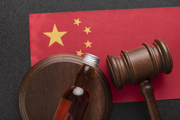 Judges Gavel and bottle of alcohol on China flag. Alcohol legislation. Law and order concept. Alcohol problems in China - Zdjęcie, obraz