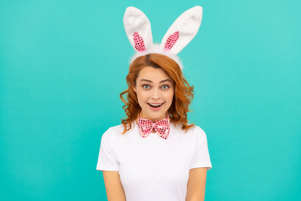 surprised easter woman in bunny ears and bow tie on blue background - Foto, imagen