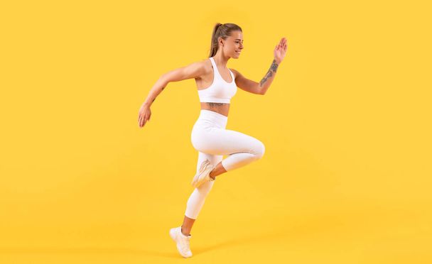 fitness meisje loper draait op gele achtergrond - Foto, afbeelding