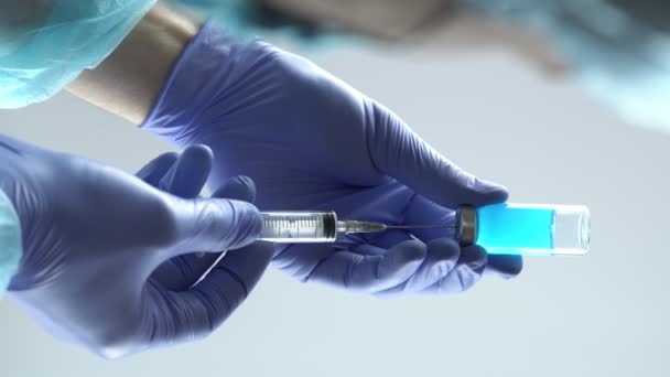 Az orvosi kesztyűt viselő orvos vagy nővér injekciós üvegből készült folyadékkal tölti meg a fecskendőt. Függőleges videó, 4k  - Felvétel, videó