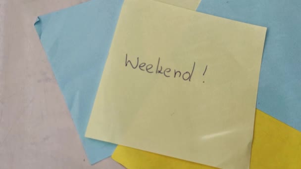Sticky note with WEEKEND word. WEEKEND message concept with magnifier - Video, Çekim