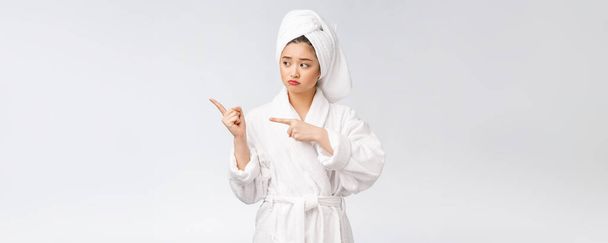 Giovane bella donna che indossa asciugamano doccia dopo il bagno su sfondo bianco isolato che punta con il dito
. - Foto, immagini