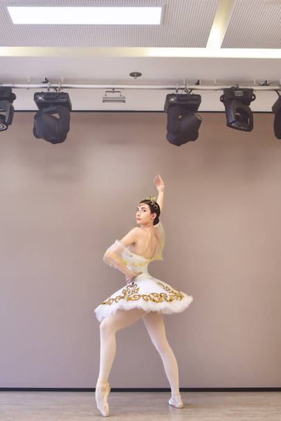 Молодая красивая балетная танцовщица готовит пируэт в танцевальной студии - Фото, изображение
