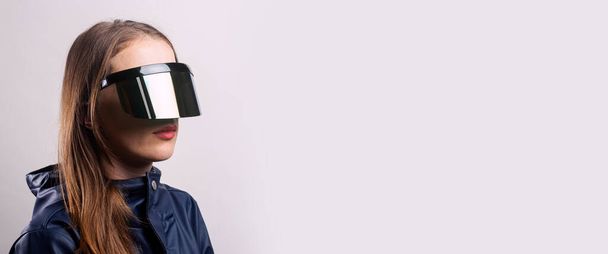 Stilvolle Frau mit VR-Brille und blauer Jacke vor hellem Hintergrund. Banner.  - Foto, Bild