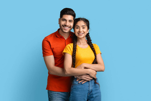 Portrait Of Smiling Young Middle Eastern Couple Embracing And Looking At Camera - Foto, Imagem