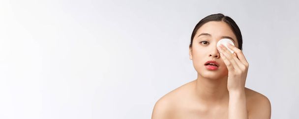 huidverzorging vrouw verwijderen van gezicht make-up met wattenstaafje - huidverzorging concept. Gezichtsclose-up van mooie gemengde ras model met een perfecte huid. - Foto, afbeelding